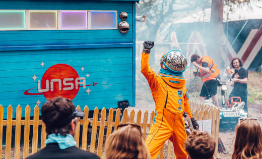 An Unlimited Space Agency astronaut performs in front of a crowd