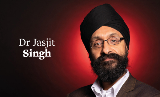 Dr Jasjit Singh in black in front of a red colour splash.