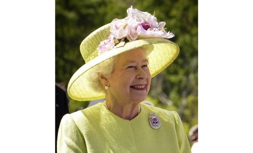 Queen Elizabeth II smiles in a lime green outfit.