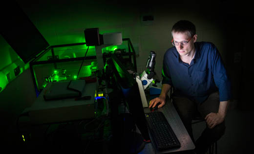 Dr Alistair Curd next to the super-resolution microscope. May 2019