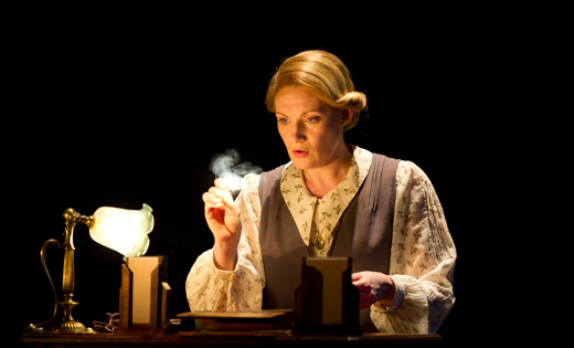An actor looks at a lit match during a production of The turn of the screw. February 2020