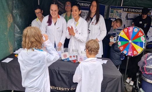 Researchers from the University smiling with children from the event