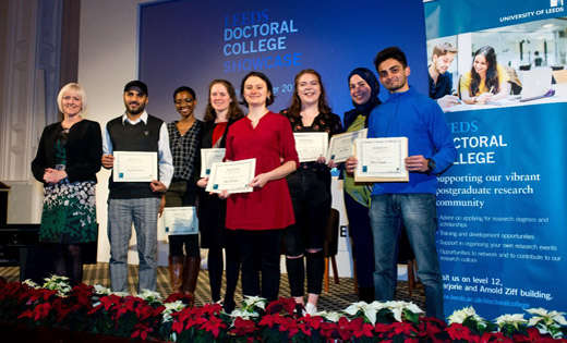 A selection of the award winners stand on stage with Lisa Roberts, the Deputy Vice-Chancellor. December 2019