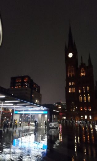 Image of a clock tower and a tube station entrance at night